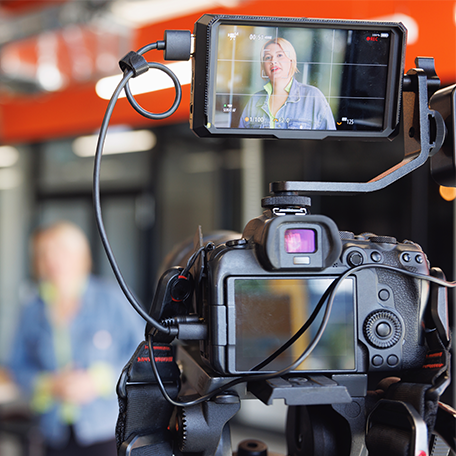 View from behind a camera as a persn is being interviewed